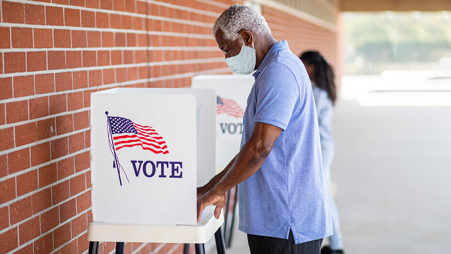 Man in mask at voting booth